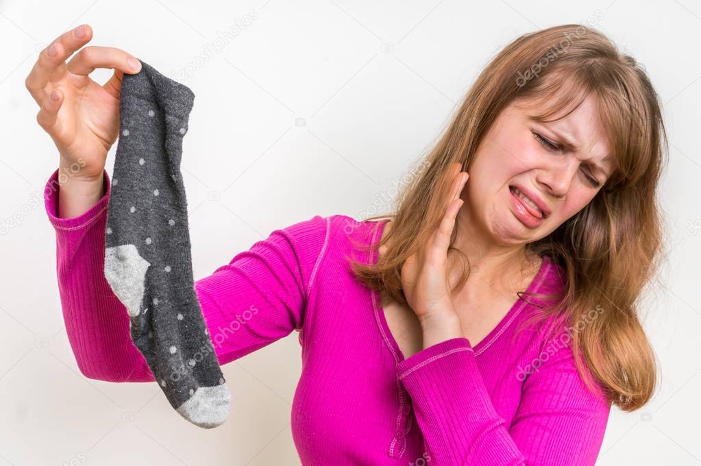 Woman with stinky sock of her husband