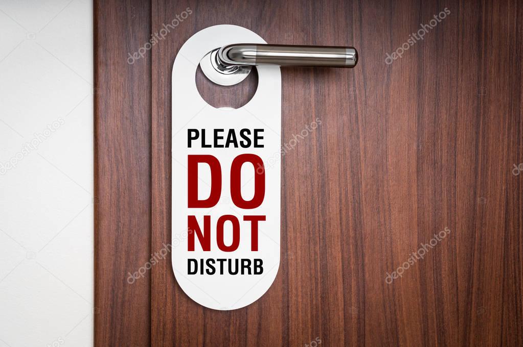 Door of hotel room with sign do not disturb