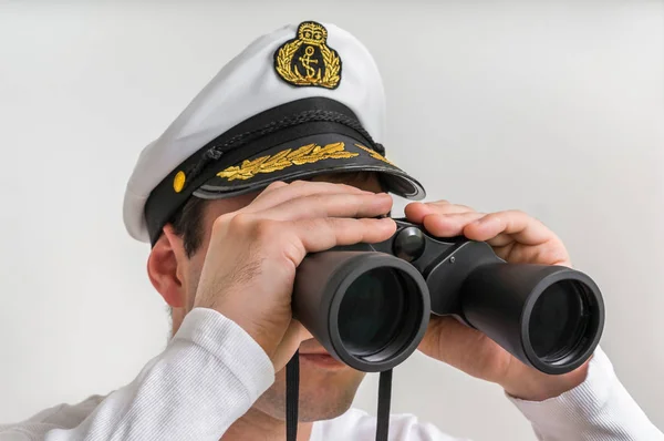 Captain looks through a binoculars — Stock Photo, Image