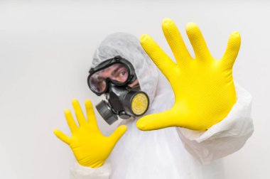 Gaz maskesi ile tulumlu adam dur jest gösterilen