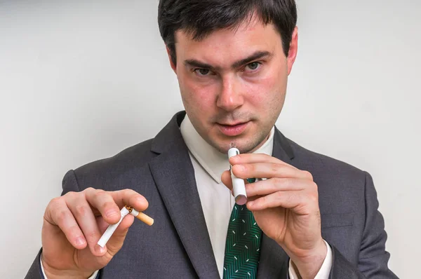 Affärsman är att jämföra elektronisk cigarett och tobak cigare — Stockfoto
