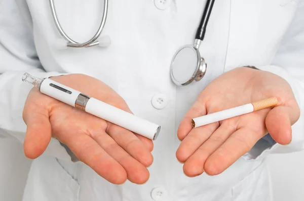 El doctor está comparando un cigarrillo electrónico y un cigarrillo de tabaco. — Foto de Stock