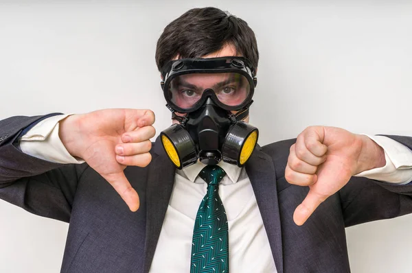 Бізнесмен з газовою маскою показує негативний жест — стокове фото