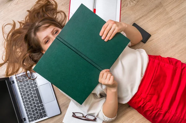 Vrouw liggend op de rug en die betrekking hebben op haar gezicht met boek — Stockfoto