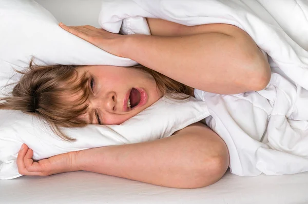 Mujer con la cabeza bajo la almohada tratando de dormir — Foto de Stock