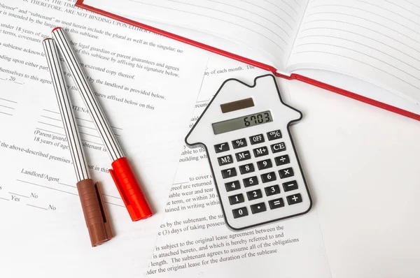 Calculadora y contrato - concepto hipotecario e inmobiliario —  Fotos de Stock