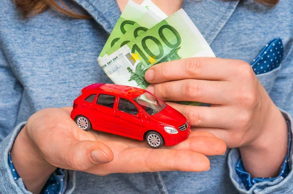 Businesswoman with money and toy red car in hands — Stock Photo, Image