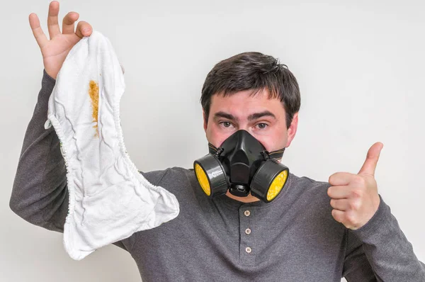 Far med gasmask ändra illaluktande blöja — Stockfoto