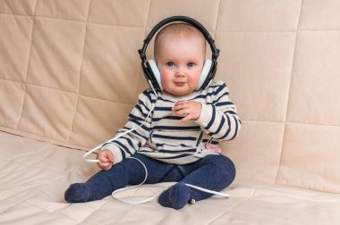 Kulaklıklar ile şirin bebek evde müzik dinliyor