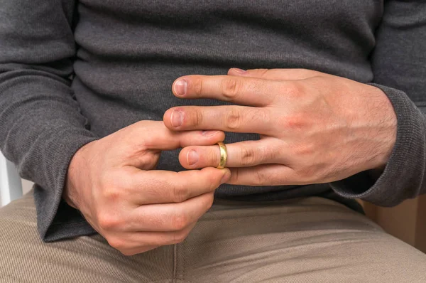 El hombre se está quitando su anillo de bodas - concepto de divorcio —  Fotos de Stock