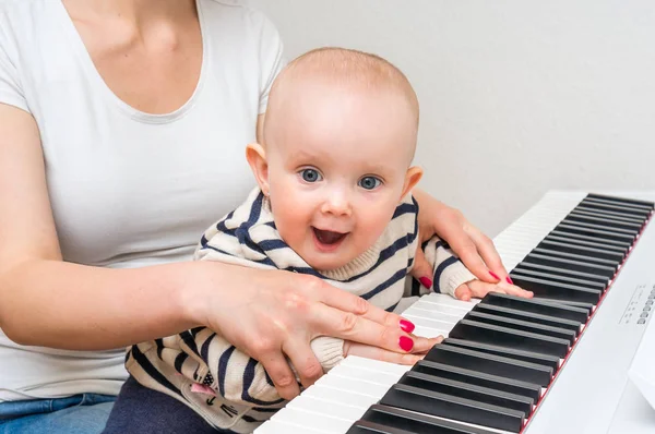 Madre enseñando a su lindo bebé a tocar el piano —  Fotos de Stock