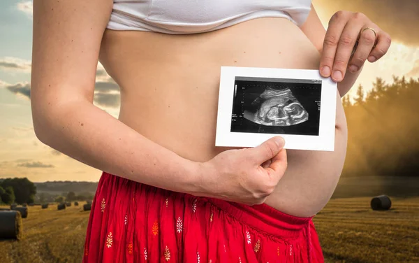 Bauch einer Schwangeren und Ultraschalluntersuchung des Babys — Stockfoto