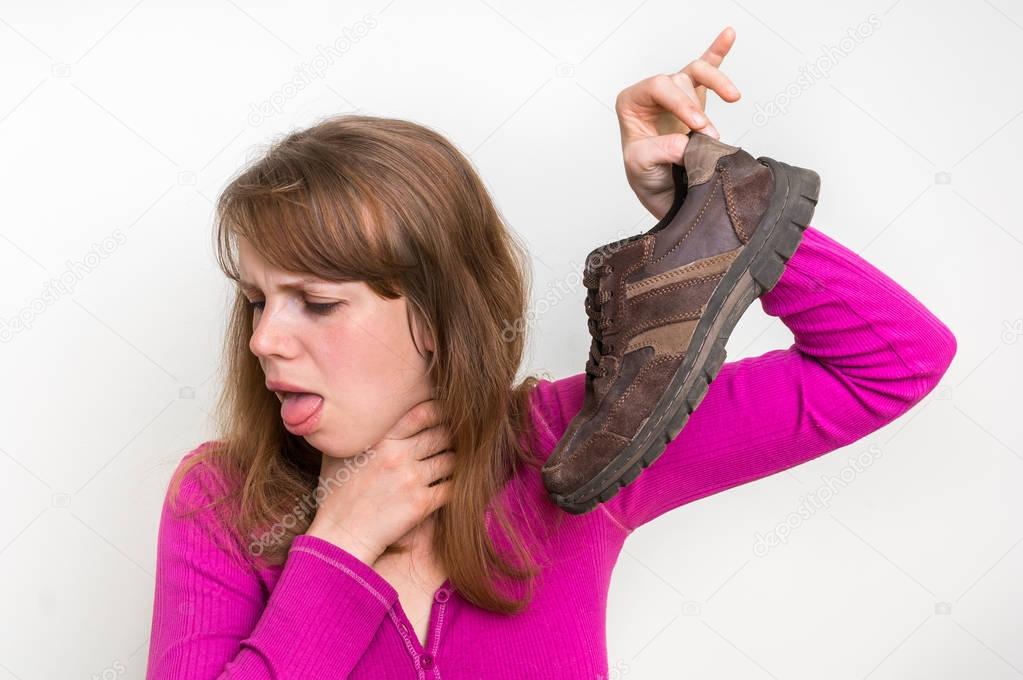 Woman with stinky shoe of her husband