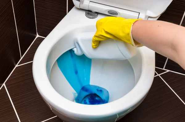 Woman is cleaning toilet bowl using detergent — Stock Photo, Image