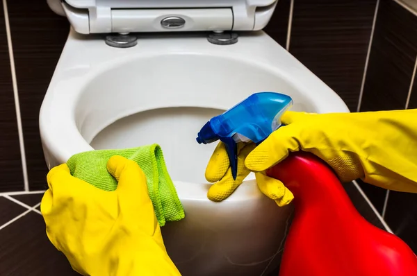 Mulher em luvas de borracha amarela está limpando vaso sanitário — Fotografia de Stock