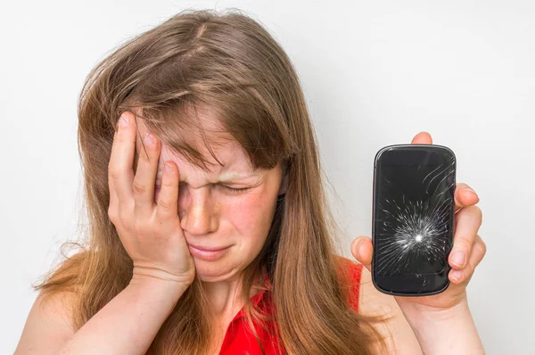 Mulher triste está segurando smartphone com tela quebrada — Fotografia de Stock