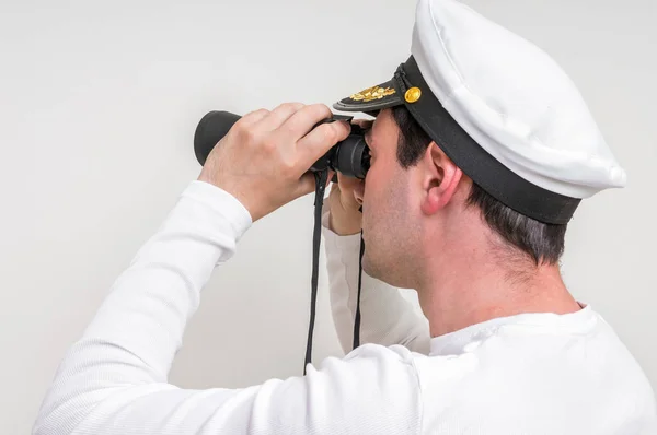 Captain looks through a binoculars — Stock Photo, Image