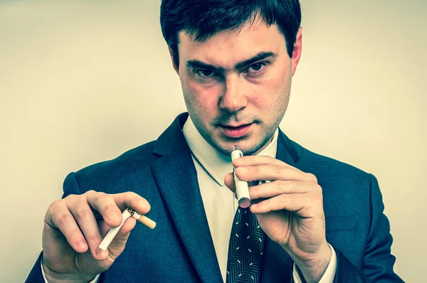 Uomo d'affari sta confrontando sigaretta elettronica e tabacco cigare — Foto Stock