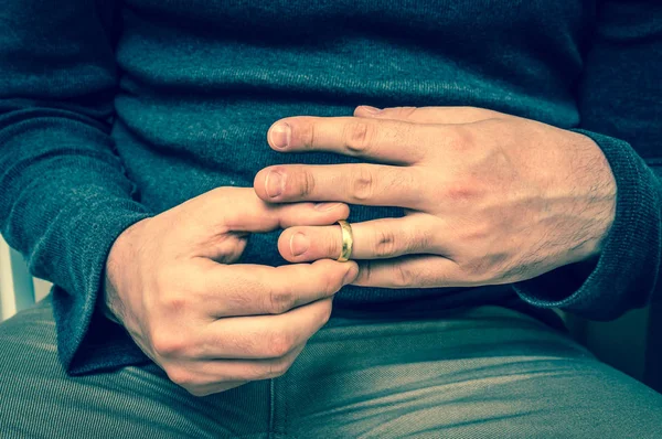 Мужчина снимает обручальное кольцо - понятие развода — стоковое фото
