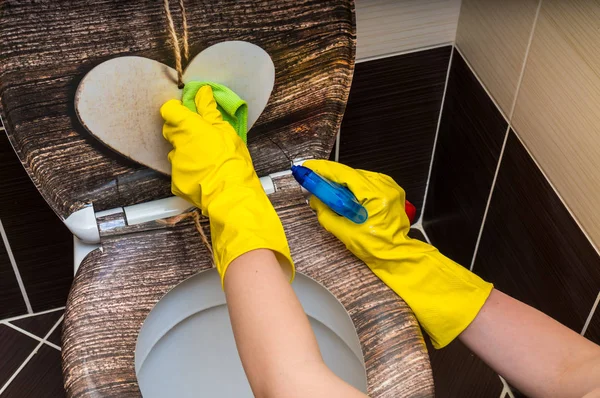 Woman in yellow rubber gloves is cleaning toilet bowl — Stock Photo, Image