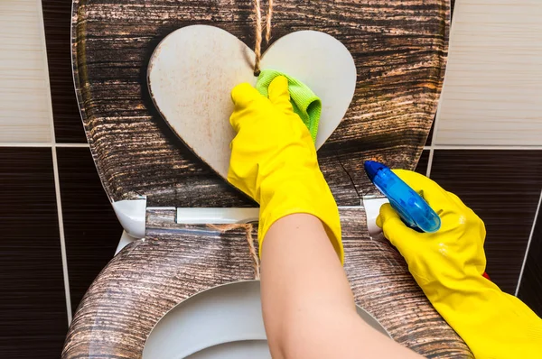 Woman in yellow rubber gloves is cleaning toilet bowl — Stock Photo, Image