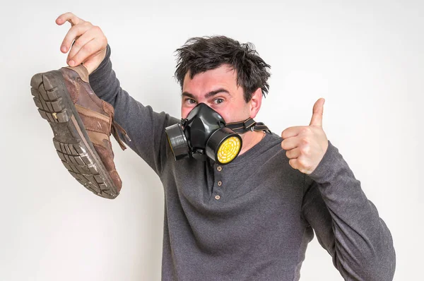 Gázálarc ember tart büdös cipő — Stock Fotó