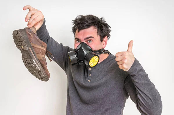 Homme avec masque à gaz tient chaussure puante — Photo