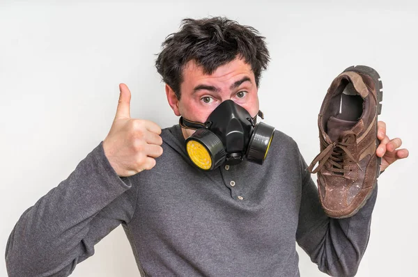Homme avec masque à gaz tient sale chaussure puante — Photo