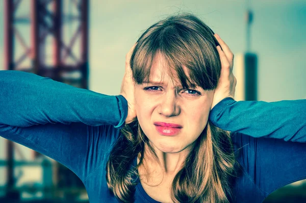 Жінка прикриває вуха, щоб захистити від гучного шуму — стокове фото