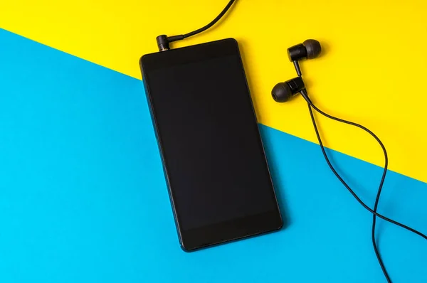 Hareket eden telefon ile renkli arka plan üzerinde kulaklık — Stok fotoğraf