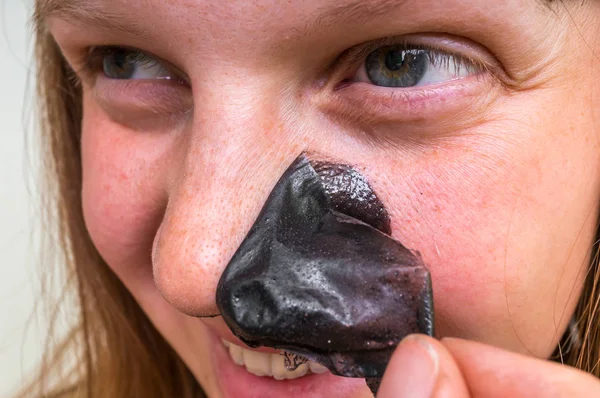 Mooie vrouw verwijdert zwarte neus masker - huid zorg concept — Stockfoto