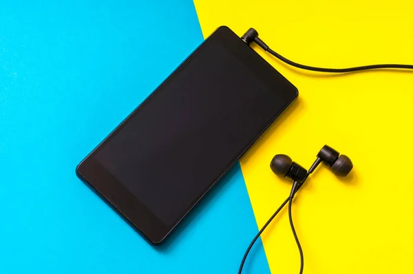 Мобільний телефон з навушниками на барвистому фоні — стокове фото