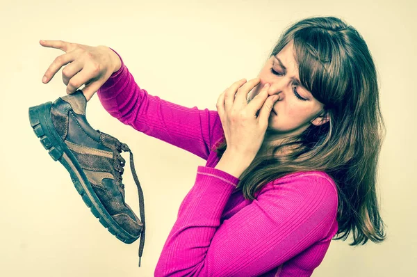 Mujer sosteniendo sucios zapatos apestosos - estilo retro —  Fotos de Stock