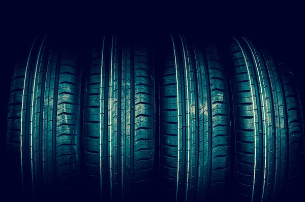 Car tires in row isolated on black - retro style — Stock Photo, Image