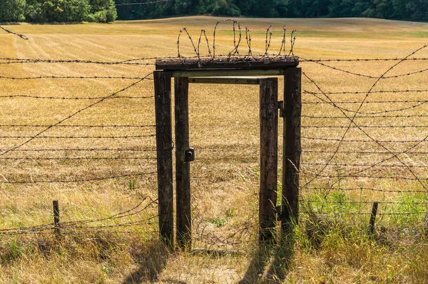 Restos de cortina de hierro con puerta dentro de la cerca de alambre — Foto de Stock