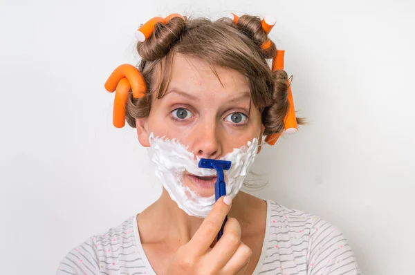 Young woman shaves her face with foam and razor — Stock Photo, Image