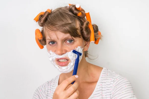Mujer joven se afeita la cara con espuma y afeitadora — Foto de Stock