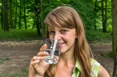 Kadın sıcak yaz gününde bardak su içiyor