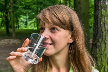 Kadın sıcak yaz gününde bardak su içiyor