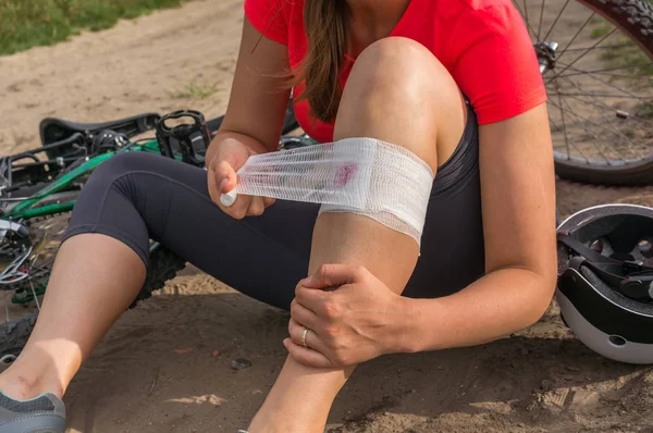 Mulher com dor no joelho depois de cair da bicicleta — Fotografia de Stock