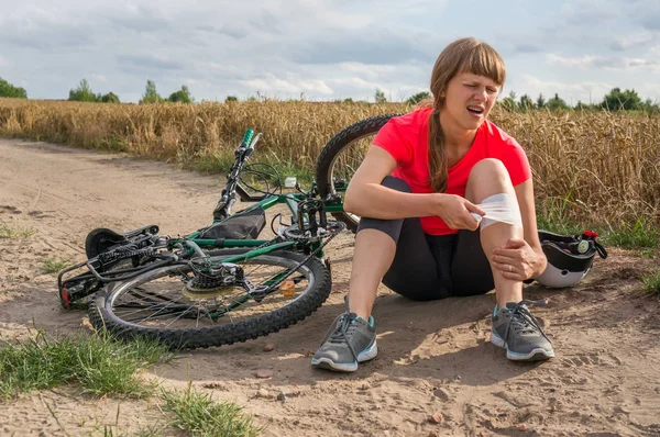 Genç kadın dağ Bisiklet düşmüş