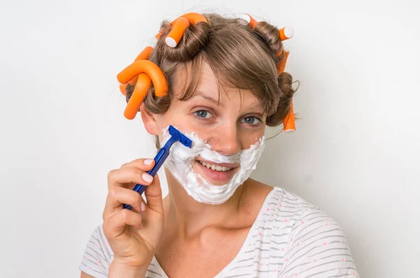 Mujer joven se afeita la cara con espuma y afeitadora — Foto de Stock