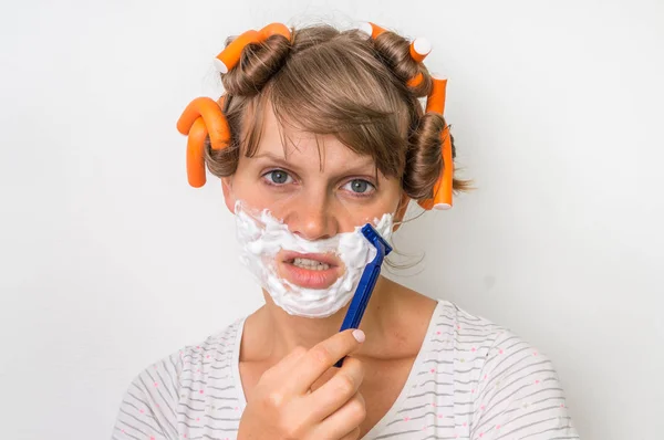 Молодая женщина бреет лицо пеной и бритвой — стоковое фото