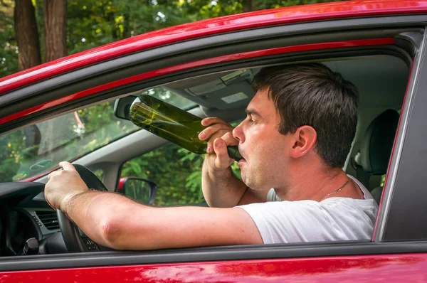 Μεθυσμένος οδηγός με μπουκάλι κρασί οδήγηση ενός αυτοκινήτου — Φωτογραφία Αρχείου