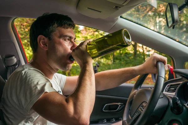 Motorista bêbado com garrafa de vinho dirigindo um carro — Fotografia de Stock