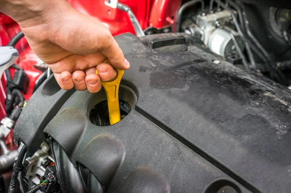 Mechanic checking the oil level in a car engine — Stock Photo, Image