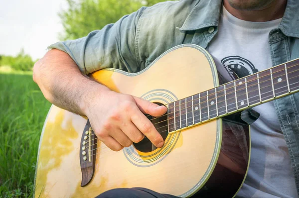 Przystojny mężczyzna gra na gitarze akustycznej — Zdjęcie stockowe