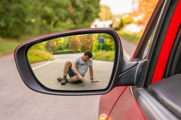 Rearview mirror with a man hit by a car — Stock Photo, Image