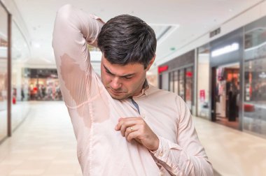 Alışveriş merkezinde koltukaltı altında terleme ile adam