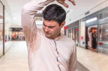 Alışveriş merkezinde koltukaltı altında terleme ile adam